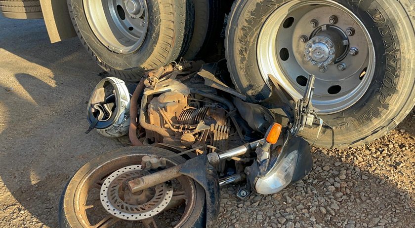Motocicleta fica presa em rodado de caminhão após colisão