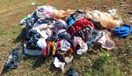 Roupas são descartadas em terreno baldio