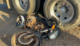 Motocicleta fica presa em rodado de caminhão após colisão