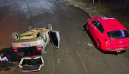Carro bate em veículo estacionado e capota