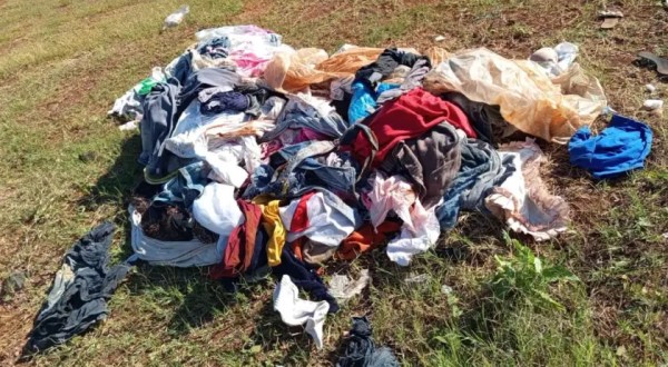 Roupas são descartadas em terreno baldio